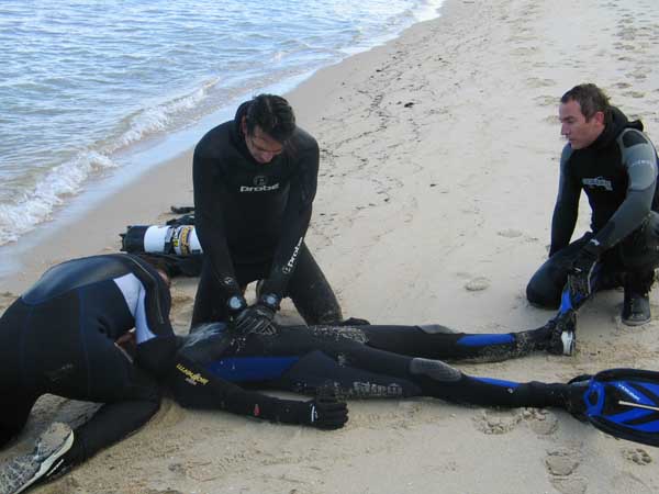Diver giving CPR on the beach